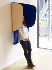 A women leaning against a blue acoustic privacy hut