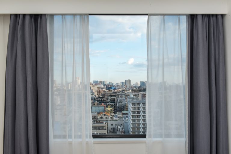 Beautiful,View,From,The,Bedroom,With,Window,Curtains,And,Cityscape,